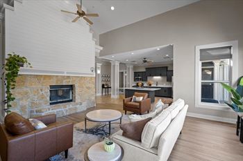 A living room with a stone fireplace and a brown leather couch. at Somerset Oaks Apartment Homes, Olathe, KS